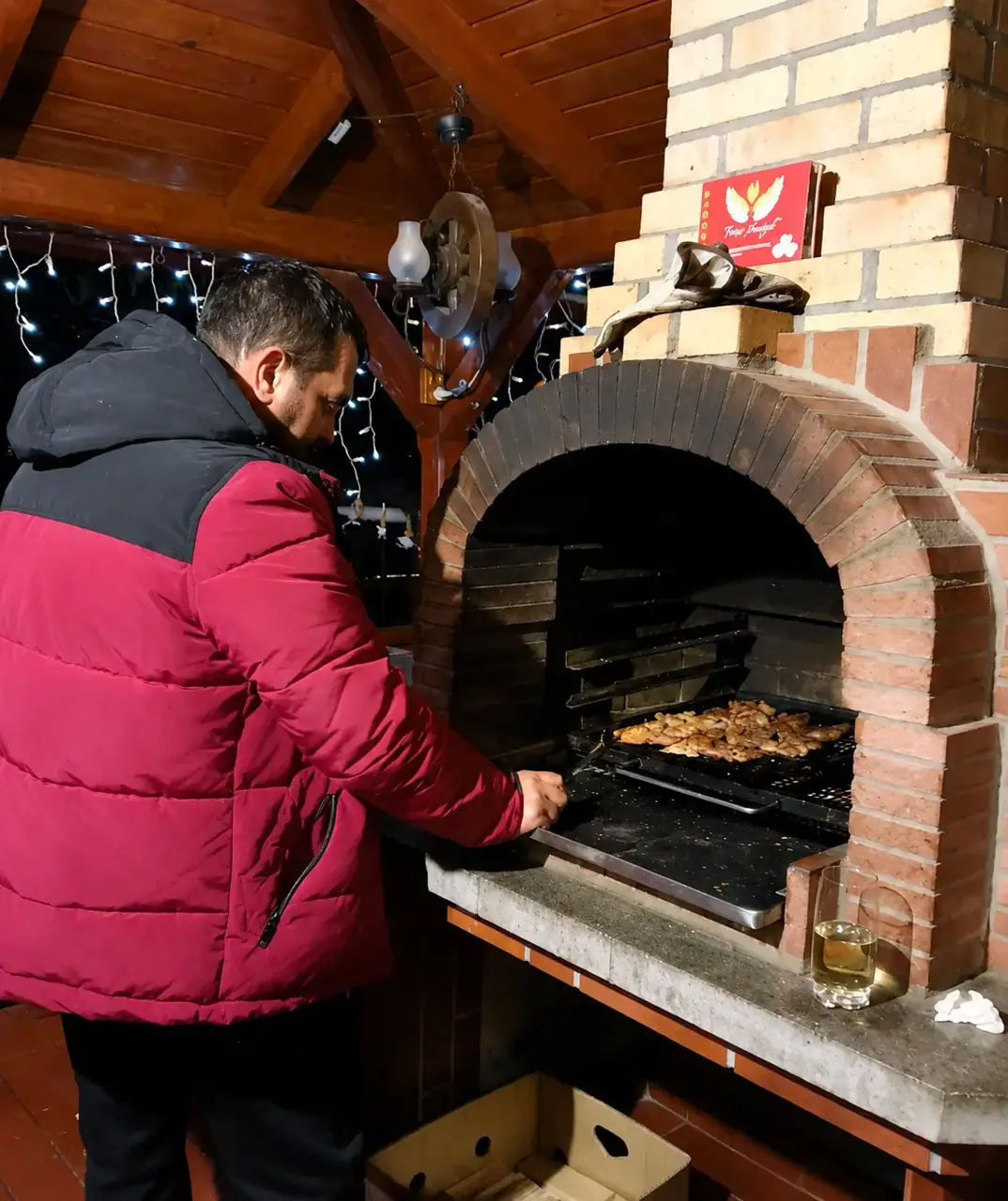 Gazda pregătind mâncare la grătar, seara